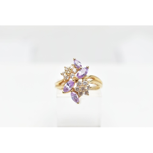 69 - A YELLOW METAL CUBIC ZIRCONIA RING, designed as two colourless cubic zirconia set flowers detailed w... 