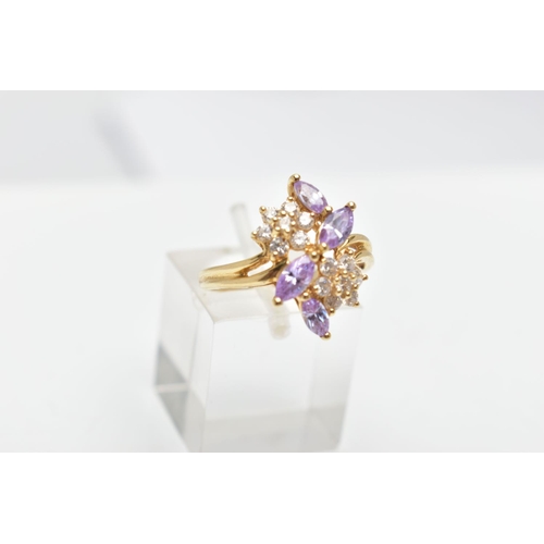 69 - A YELLOW METAL CUBIC ZIRCONIA RING, designed as two colourless cubic zirconia set flowers detailed w... 