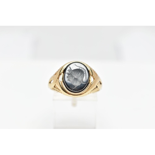 70 - A 9CT GOLD HEMATITE INTAGLIO SIGNET RING, of an oval form depicting a side profile of a soldier wear... 