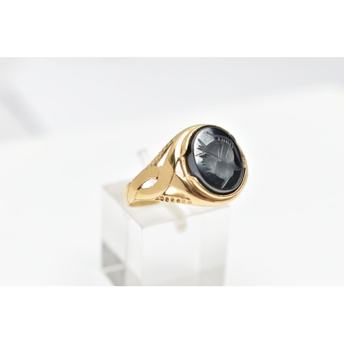 70 - A 9CT GOLD HEMATITE INTAGLIO SIGNET RING, of an oval form depicting a side profile of a soldier wear... 