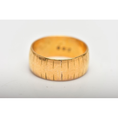 9 - A 22CT GOLD WEDDING BAND, designed as a plain polished band with engraved line detail, approximate r... 