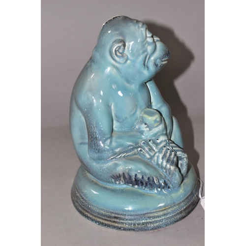 339 - A BESWICK MONKEY FIGURE, number 397, seated on a circular pottery base, holding a piece of fruit, pa... 