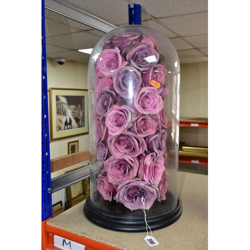 390 - A MODERN GLASS DOME ON A CIRCULAR EBONISED BASE, containing an arrangement of pink fabric roses, hei... 