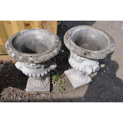 1008 - A PAIR OF MODERN COMPOSITE GARDEN URNS one piece in construction with dual mask motifs on opposing s... 