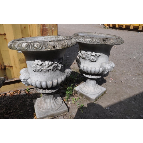 1008 - A PAIR OF MODERN COMPOSITE GARDEN URNS one piece in construction with dual mask motifs on opposing s... 