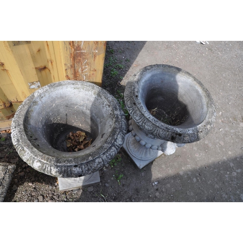 1008 - A PAIR OF MODERN COMPOSITE GARDEN URNS one piece in construction with dual mask motifs on opposing s... 