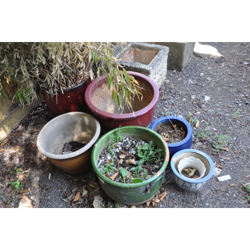 1018 - SIX GLAZED GARDEN PLANTERS the largest being red glazed, planted with foliage 40cm in diameter taper... 