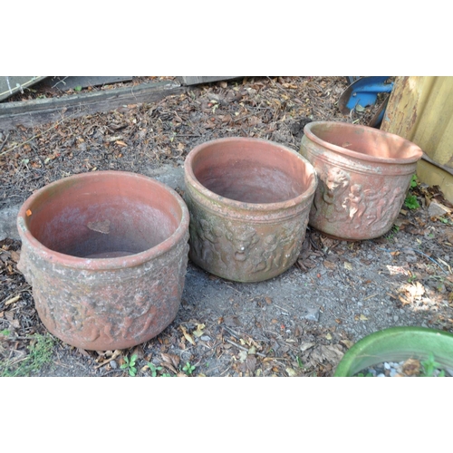 1019 - A SET OF THREE TERRACOTTA PLANT POTS with lion mask and cherub detailing 41cm in diameter and 36cm h... 