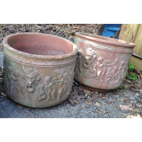 1019 - A SET OF THREE TERRACOTTA PLANT POTS with lion mask and cherub detailing 41cm in diameter and 36cm h... 