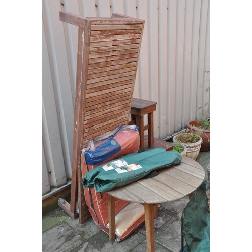 1029 - A HARDWOOD SLATTED SUN LOUNGER with wheels on one end and cushion cover length 191cm, a round hardwo... 