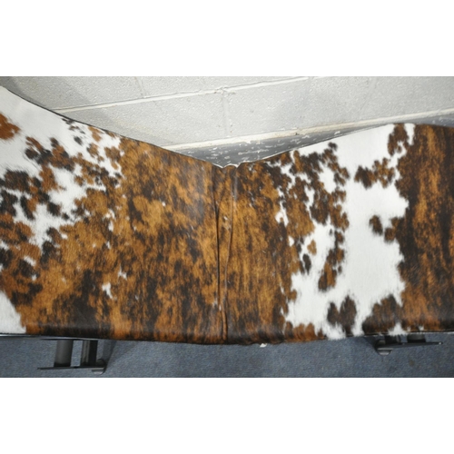 1232 - IN THE MANNER OF LE CORBUSIER, a cow hide lc4 chaise longue, with a chrome frame, on a metal frame b... 