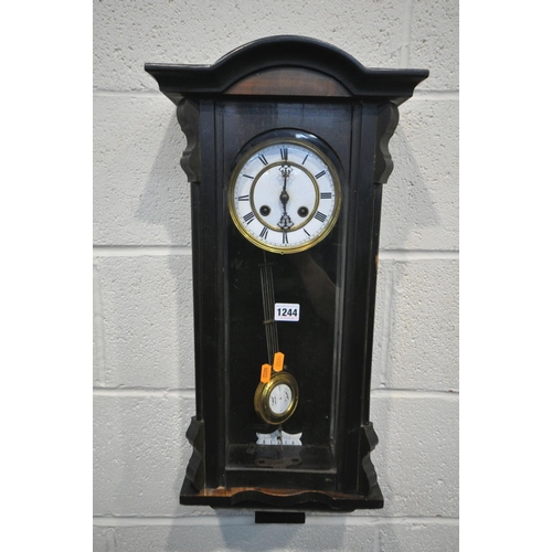 1244 - AN EARLY 20TH CENTURY EBONISED WALL CLOCK, the enamel dial with roman numerals, height 67cm (winding... 