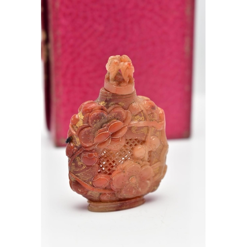 28 - A CARVED CARNELIAN PIERCED BOTTLE, of oriental design with various carved flowers and textured motif... 