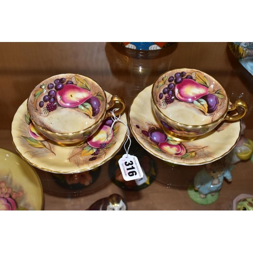 316 - A PAIR OF AYNSLEY ORCHARD GOLD TEA CUPS AND SAUCERS, with gilt handles and rims, printed with fruit ... 