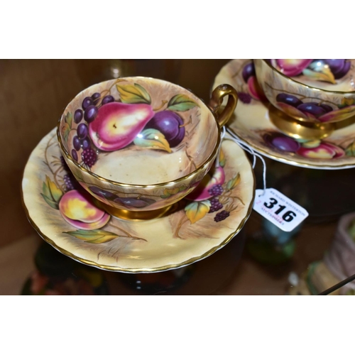 316 - A PAIR OF AYNSLEY ORCHARD GOLD TEA CUPS AND SAUCERS, with gilt handles and rims, printed with fruit ... 