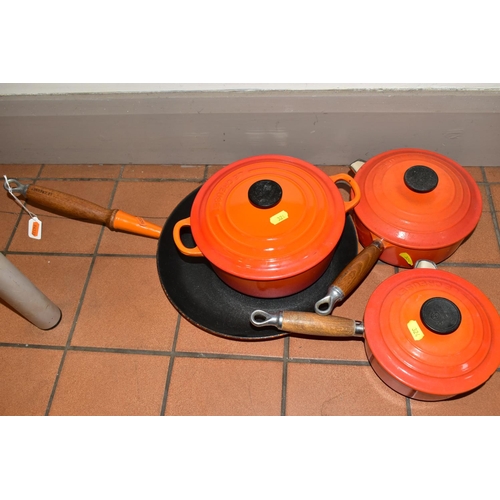 324 - FOUR PIECES OF LE CREUSET CAST IRON COOK WARE, all with orange enamel finish, comprising a twin hand... 