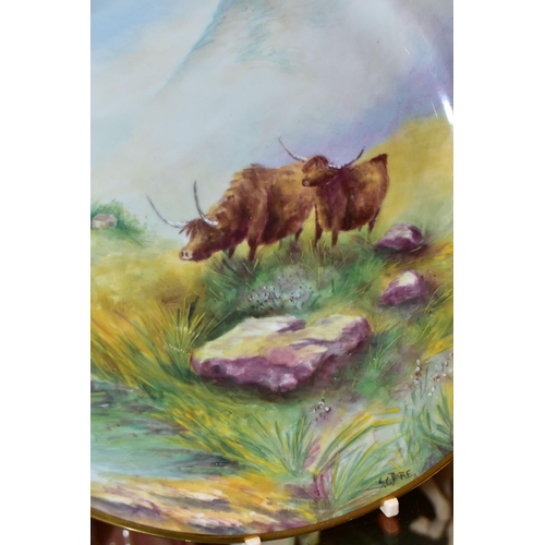 359 - A PAIR OF PLATES HAND PAINTED WITH SCENES OF HIGHLAND CATTLE, in naturalistic Highland setting, sign... 