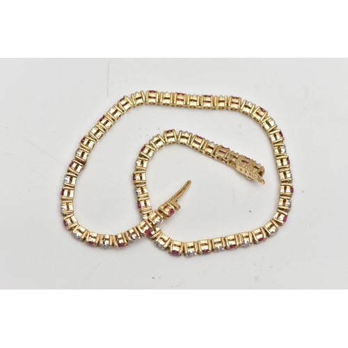 7 - A 9CT YELLOW GOLD DIAMOND AND RUBY LINE BRACELET, set with approximately thirty one round brilliant ... 