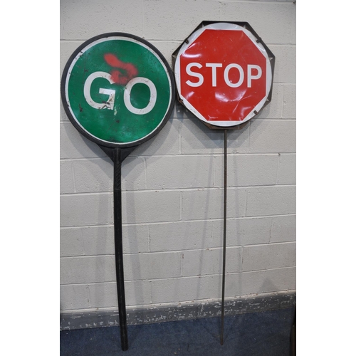 1083 - TWO VINTAGE STOP AND GO SIGNS comprising a steel sign and another plastic stop and go sign, along wi... 