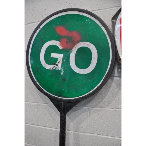 1083 - TWO VINTAGE STOP AND GO SIGNS comprising a steel sign and another plastic stop and go sign, along wi... 