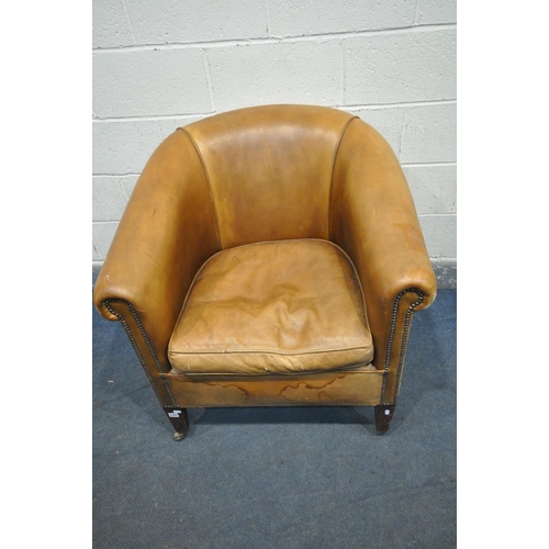 1323 - A TANNED LEATHER TUB CHAIR, on front square tapering legs, with brass casters, width 87cm x depth 82... 