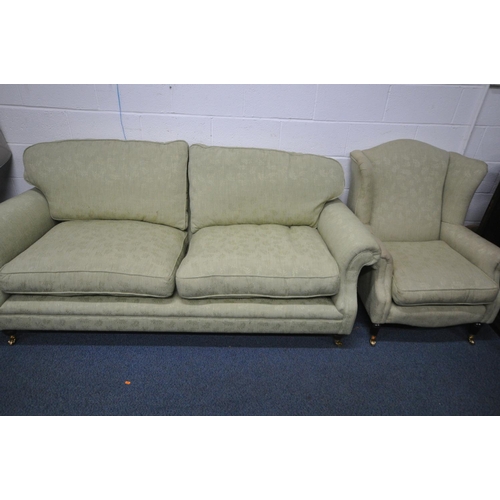 1329 - A GREEN UPHOLSTERED TWO PIECE LOUNGE SUITE, comprising a three seater settee, length 212cm, and a wi... 