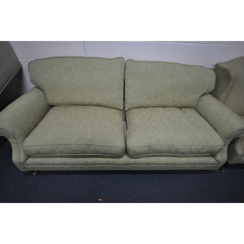 1329 - A GREEN UPHOLSTERED TWO PIECE LOUNGE SUITE, comprising a three seater settee, length 212cm, and a wi... 