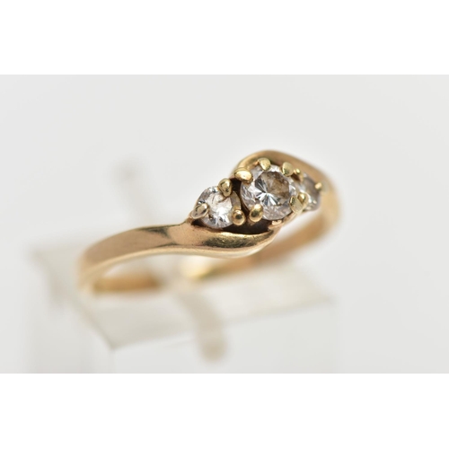 5 - A 9CT GOLD DIAMOND THREE STONE RING, comprising three graduated brilliant cut diamonds, to the asymm... 