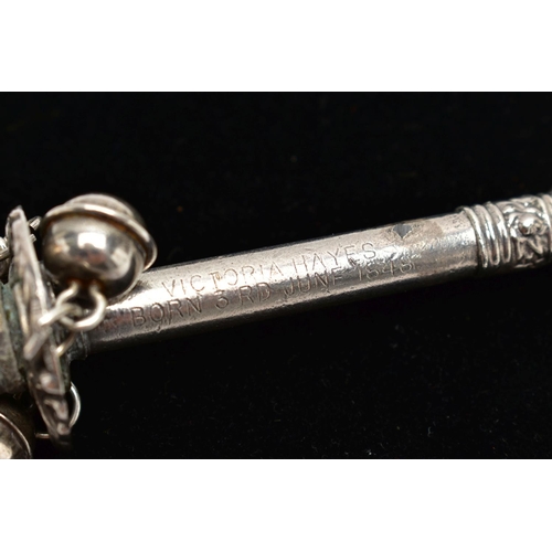 71 - A MID 19TH CENTURY WHITE METAL BABY RATTLE, depicting a character to the top, suspending three jingl... 