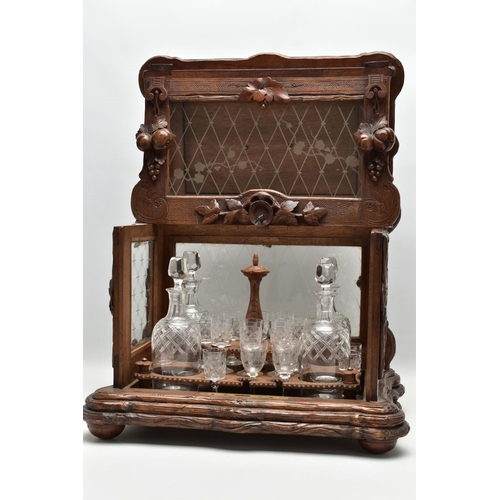 219 - A LATE 19TH CENTURY AND LATER BLACK FOREST CARVED AND STAINED WALNUT TANTALUS, carved surmount of a ... 