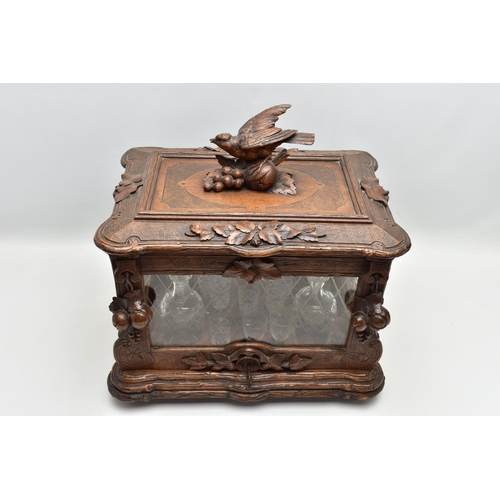 219 - A LATE 19TH CENTURY AND LATER BLACK FOREST CARVED AND STAINED WALNUT TANTALUS, carved surmount of a ... 