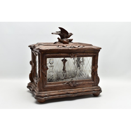 219 - A LATE 19TH CENTURY AND LATER BLACK FOREST CARVED AND STAINED WALNUT TANTALUS, carved surmount of a ... 