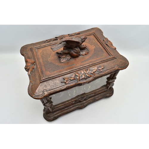 219 - A LATE 19TH CENTURY AND LATER BLACK FOREST CARVED AND STAINED WALNUT TANTALUS, carved surmount of a ... 