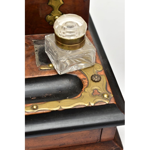 220 - A VICTORIAN BRASS MOUNTED WALNUT AND EBONISED DESKSTAND, fitted with an arched stationery box, two g... 