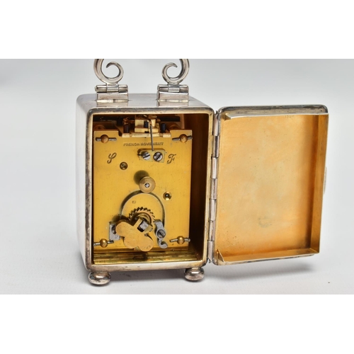 23 - AN EDWARDIAN WILLIAM COMYNS MINIATURE SILVER BOUDOIR CLOCK, the plain case with swing carrying handl... 
