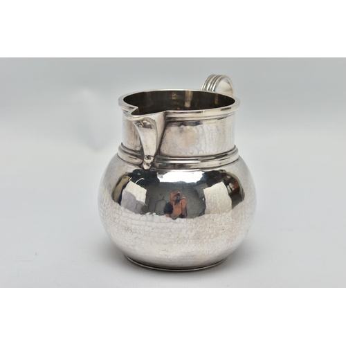 34 - A GEORGE V SILVER JUG OF SQUAT BALUSTER FORM, the S scroll reeded handle on a planished body, makers... 