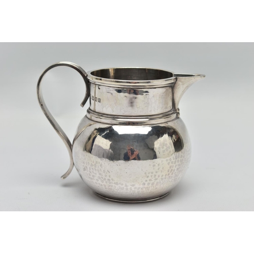 34 - A GEORGE V SILVER JUG OF SQUAT BALUSTER FORM, the S scroll reeded handle on a planished body, makers... 