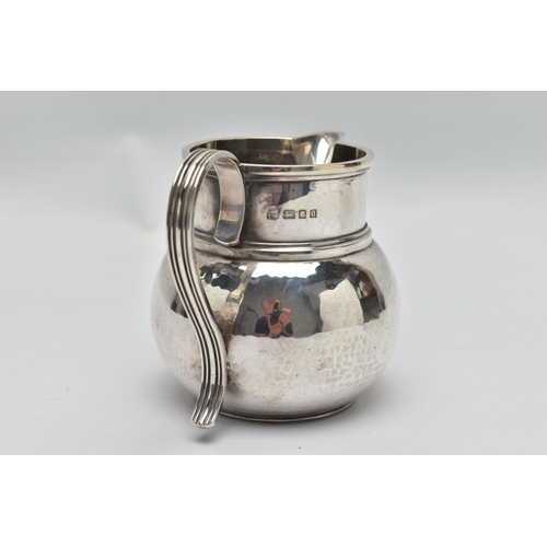 34 - A GEORGE V SILVER JUG OF SQUAT BALUSTER FORM, the S scroll reeded handle on a planished body, makers... 