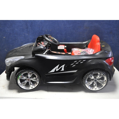 1052 - A CHILDRENS ELECTRIC RIDE ON CAR, with remote control capability, charger and instruction manual (UN... 