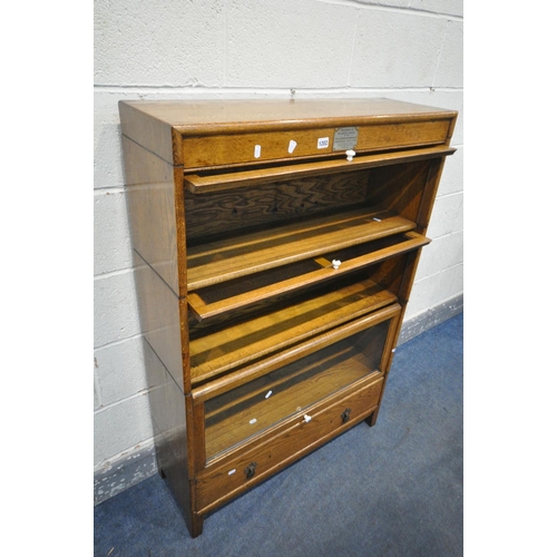 1202 - AN EARLY TO MID 20TH CENTURY OAK THREE SECTIONAL BOOKCASE, with three glazed hide and fall doors, ab... 