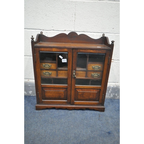 1211 - AN EARLY 20TH CENTURY OAK SMOKERS CABINET, with two bevelled glass doors, that enclosing a fitted in... 