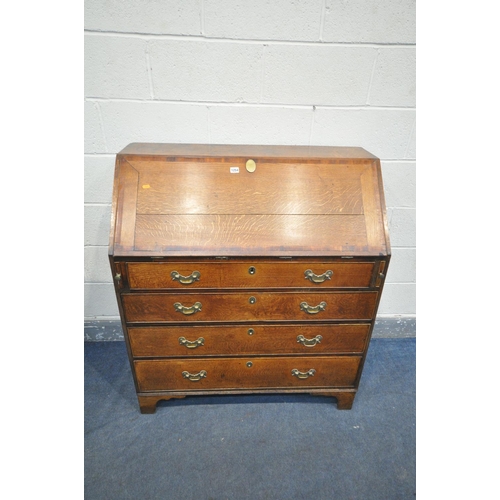 1254 - A GEORGIAN OAK AND MAHOGANY CROSSBANDED BUREAU, the fall front enclosing a fitted interior, above fo... 