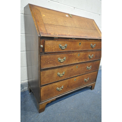 1254 - A GEORGIAN OAK AND MAHOGANY CROSSBANDED BUREAU, the fall front enclosing a fitted interior, above fo... 