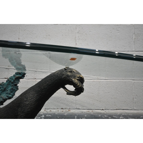 1401 - AN GLASS TOP OVAL COFFEE TABLE, the base in the form of an otter hunting a fish, length 140cm x dept... 