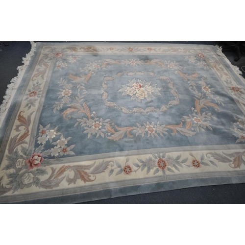 1414 - A LARGE RECTANGULAR BLUE GROUND CHINESEWOOLEN RUG, with multistrap border, and foliate decorations, ... 