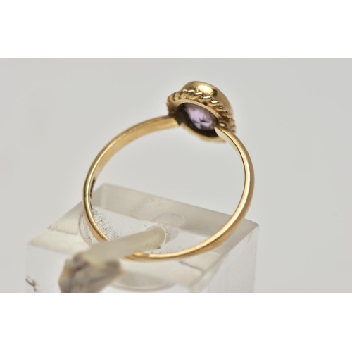 20 - A 9CT GOLD AMETHYST SINGLE STONE RING, the oval cut amethyst within a collet setting, to the rope tw... 