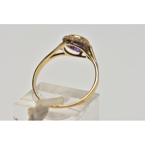 21 - A 9CT GOLD AMETHYST SINGLE STONE RING, the oval cut amethyst within a collet setting, to the openwor... 