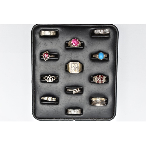 33 - A SELECTION OF SILVER AND MAINLY WHITE METAL RINGS, sitting on a ring pad comprising twelve rings, t... 