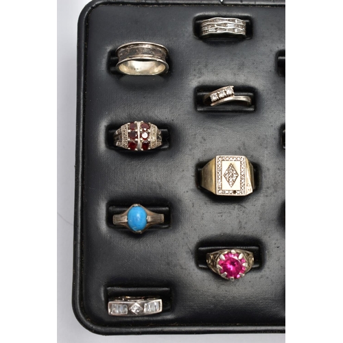 33 - A SELECTION OF SILVER AND MAINLY WHITE METAL RINGS, sitting on a ring pad comprising twelve rings, t... 