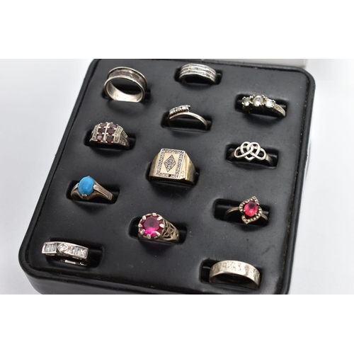 33 - A SELECTION OF SILVER AND MAINLY WHITE METAL RINGS, sitting on a ring pad comprising twelve rings, t... 